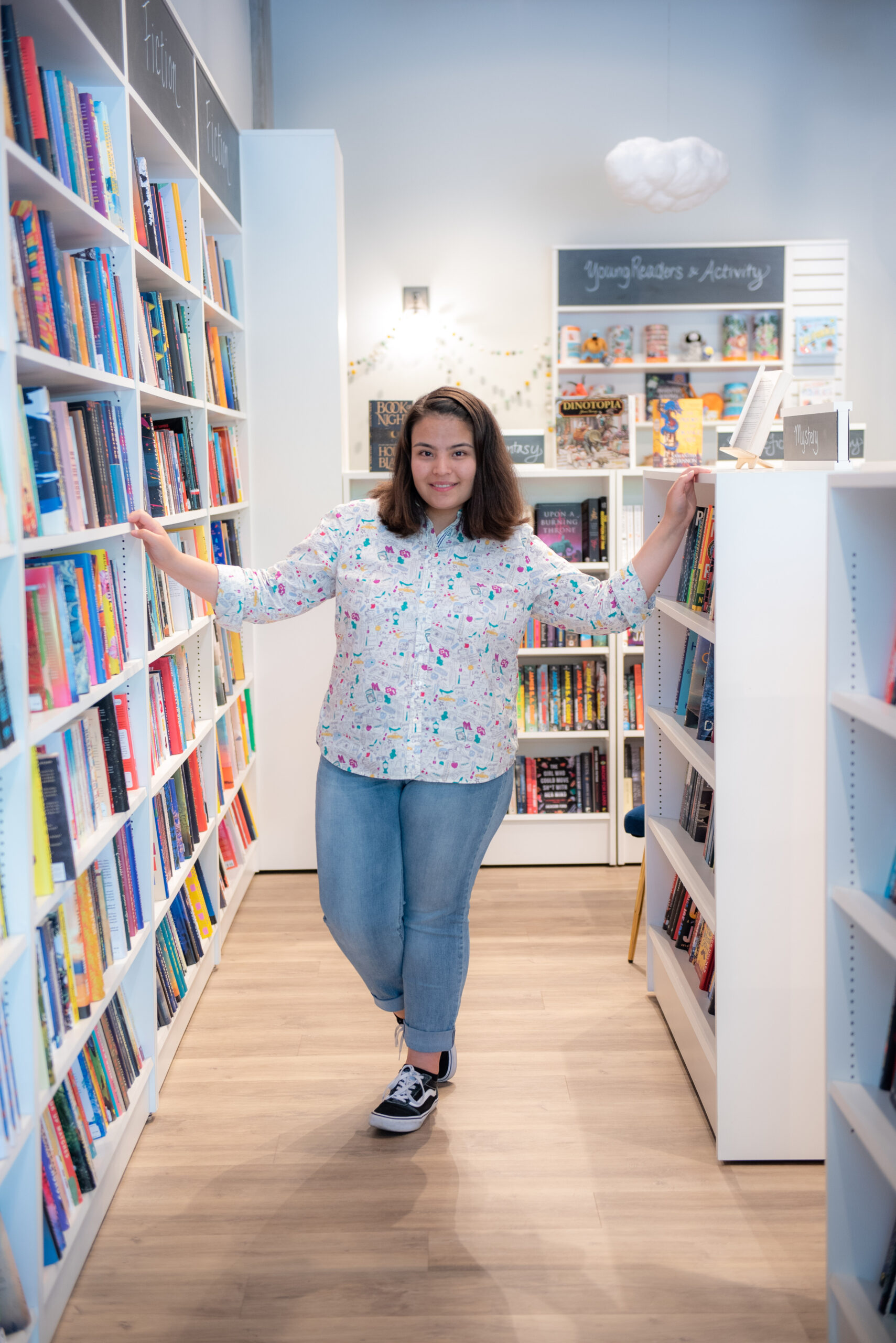 Teen girl between bookshelves in bookstore