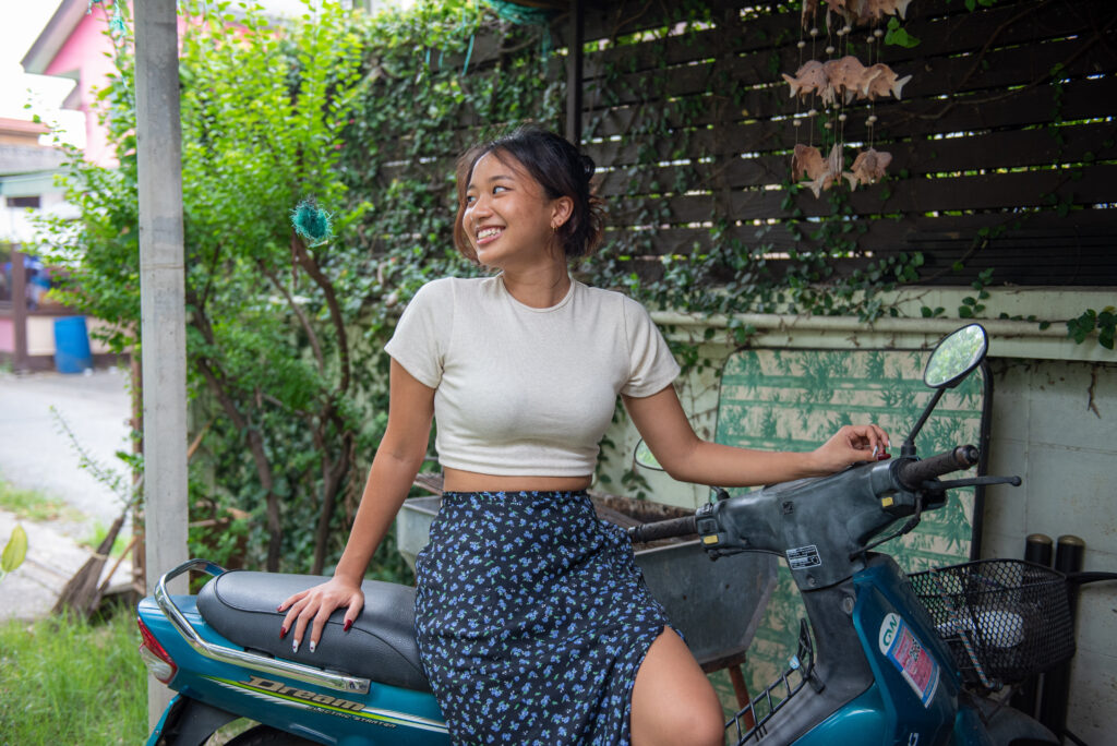 teen girl navy skirt white shirt lean on motorbike looking away