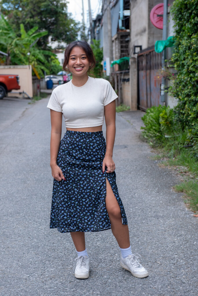 teen girl in navy skirt white shirt standing on back street