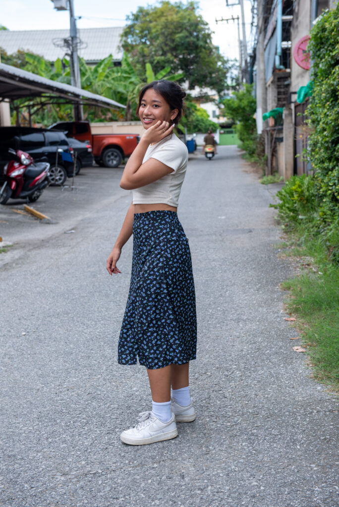 teen girl navy skirt white top pose in middle of side street