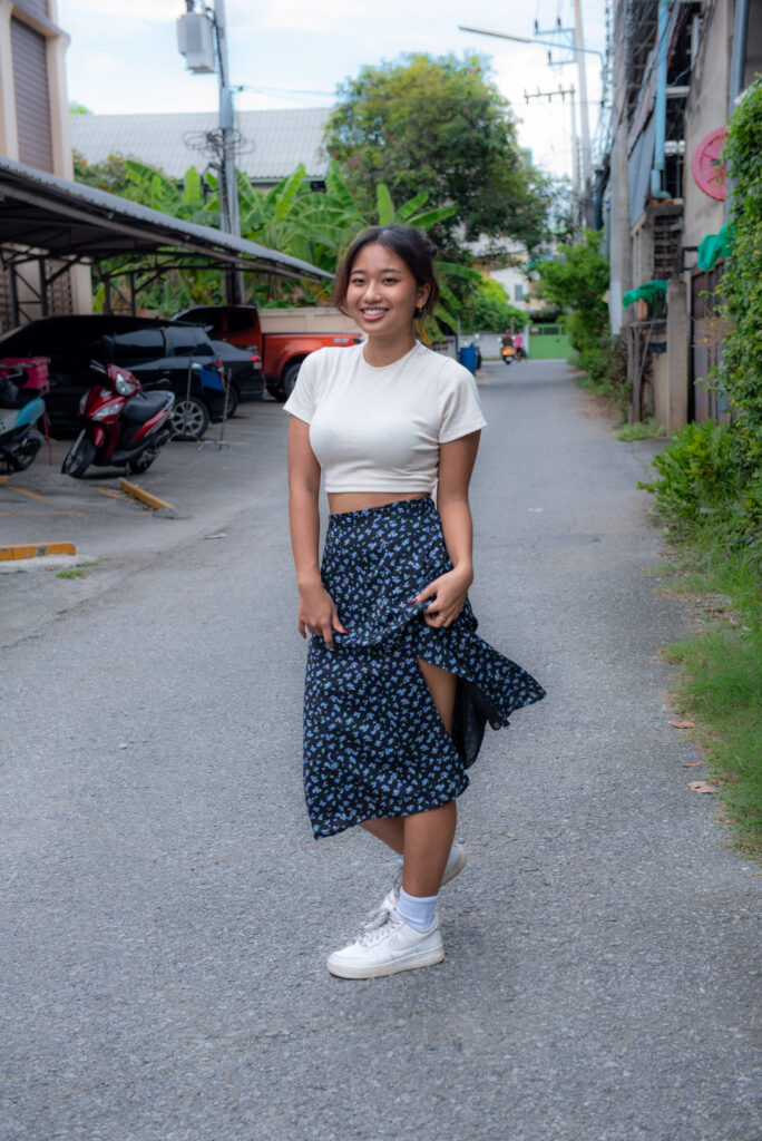 teen girl navy skirt white top pose in middle of side street