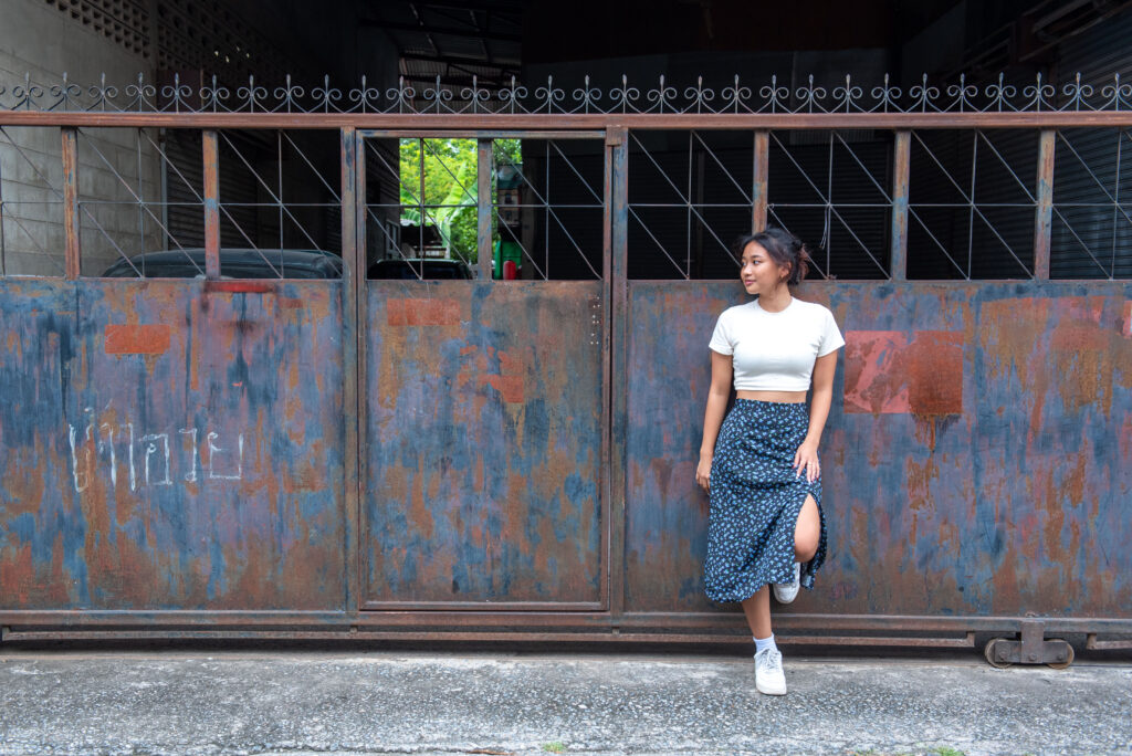 teen girl navy skirt leaning on metal gate