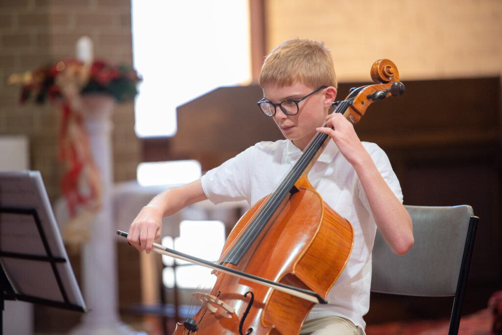 teen cellist focuses intently on performance